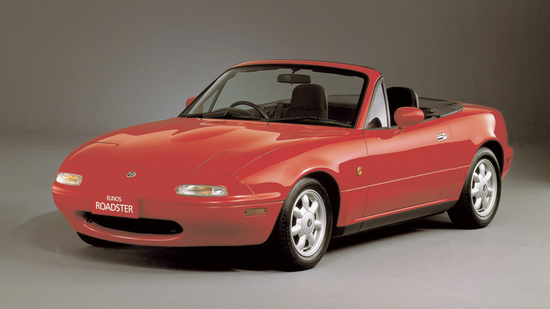 a reddish mazda miata parked successful a show room