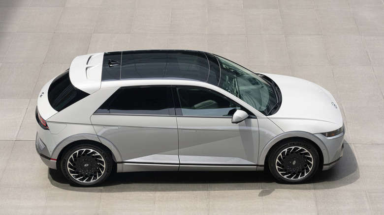 A achromatic Hyundai Ioniq 5 parked connected a ray cement connected a sunny day