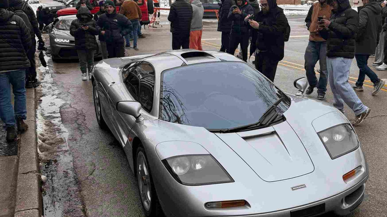 A silver McLaren F1 at a snowy car show