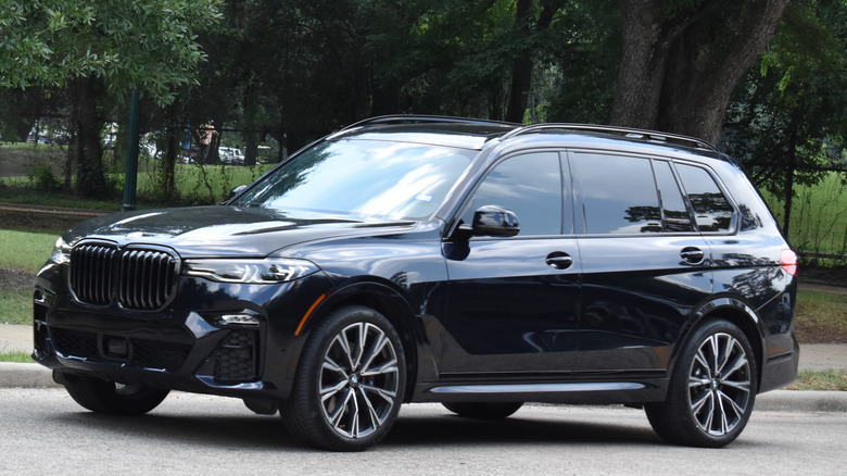 A black BMW X5 driving on a road.
