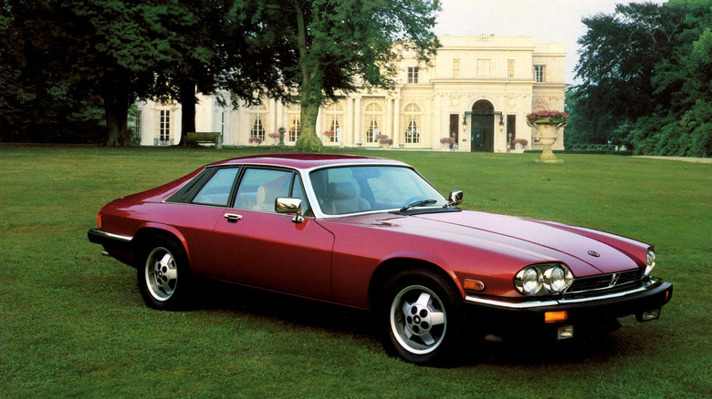 Front 3/4 view of a red Jaguar XJS in front of a castle