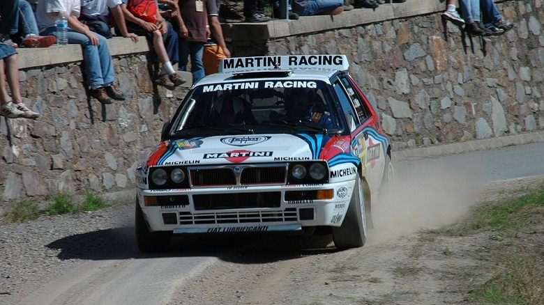 A Martini Racing liveried Lancia Delta Integrale takes the curve of a paved/dirt road in the 2007 Rallye Deutschland.