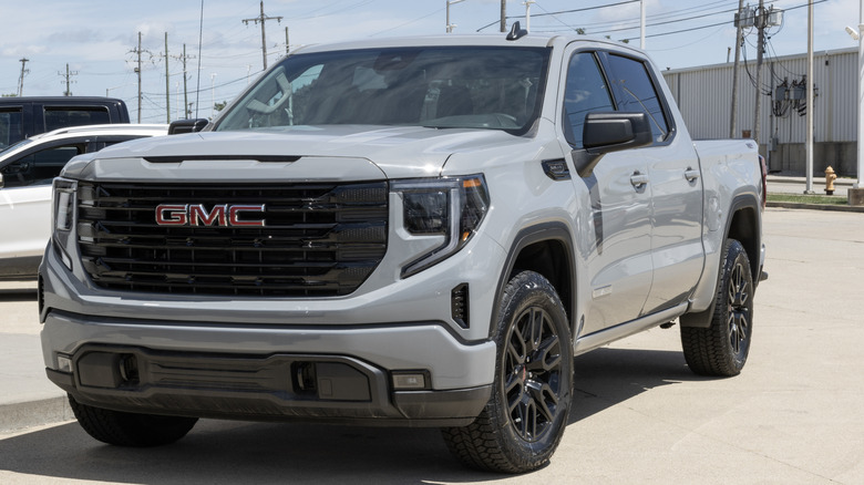 Gray 2024 GMC Sierra X31 pickup truck front left view seen in a parking lot