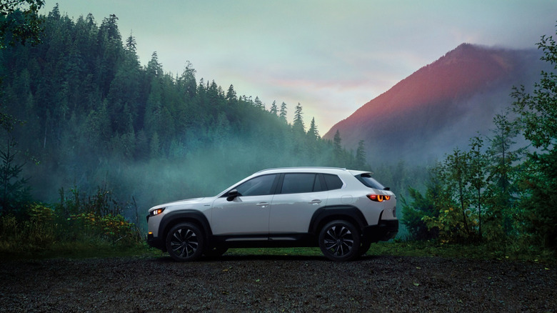 A gray Mazda CX-50 parked in front of a scenic mountain background.