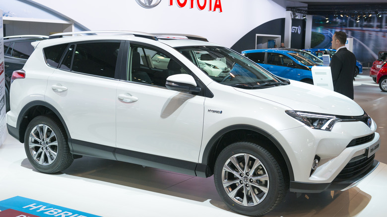 White Toyota RAV4 Hybrid crossover on display at an auto show