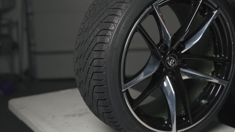 A Continental VikingContact 7 tire placed on a white table.