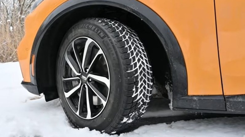 A Michelin X Ice Snow tire on snowy ground.