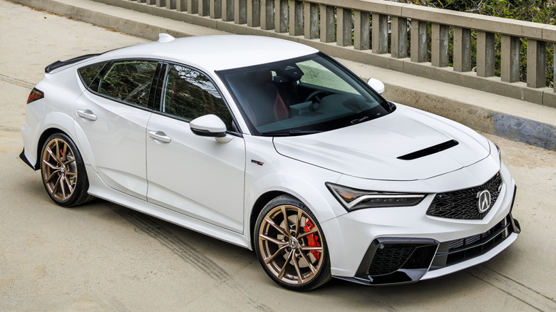 A white Acura Integra Type S parked on a bridge.