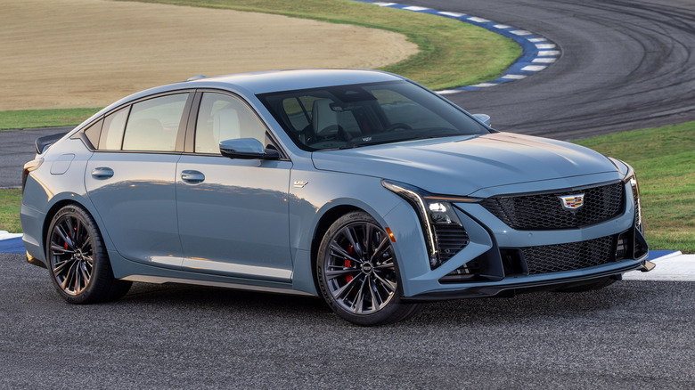 A "Drift Metallic" paint Cadillac CT5-V Blackwing parked on the curb of a racetrack.