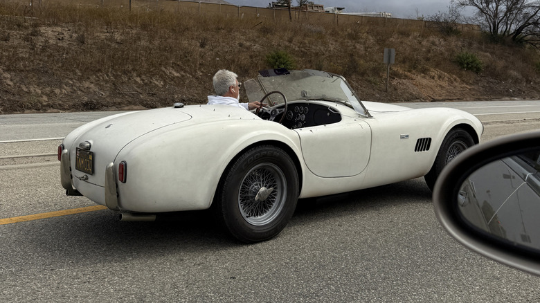 A white AC Cobra driving on PCH
