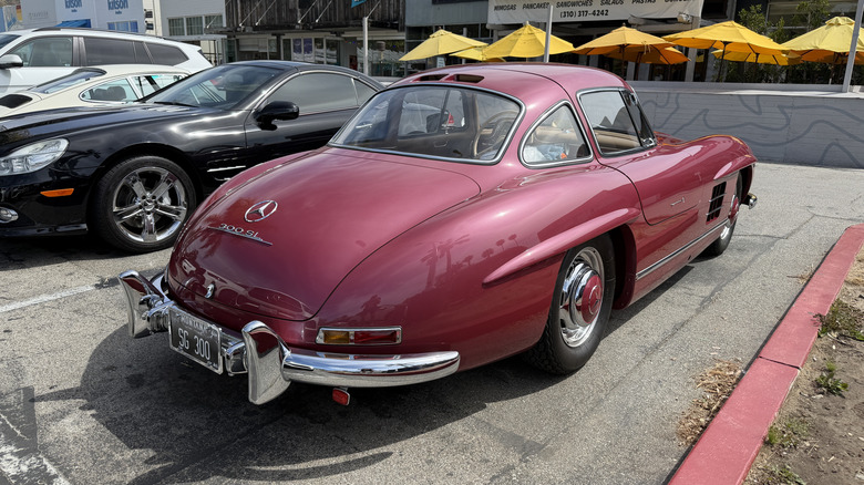 Rear 3/4 view of a strawberry Mercedes 300SL