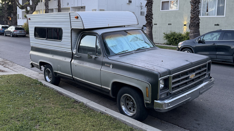 Front 3/4 view of a Chevy truck with a camper on the back