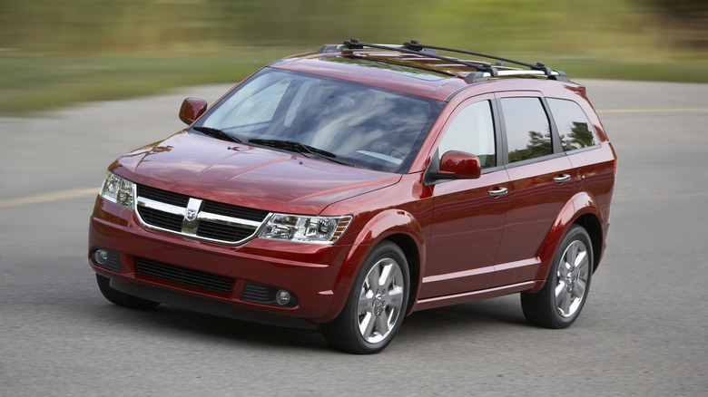 A red 2009 Dodge Journey egg-shaped vehicle on an assumed grass-surrounded Michigan roadway.