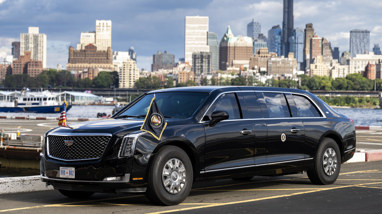 The presidential limo, coined "the Beast," a mix between what looks like a Cadillac Escalade and a car, sits on a parking lot with the New York City skyline in the background.