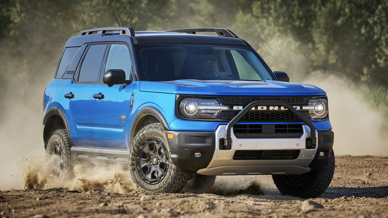 A blue Bronco Sport driving through dirt