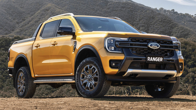 Yellow Ford Ranger parked in front of green hills