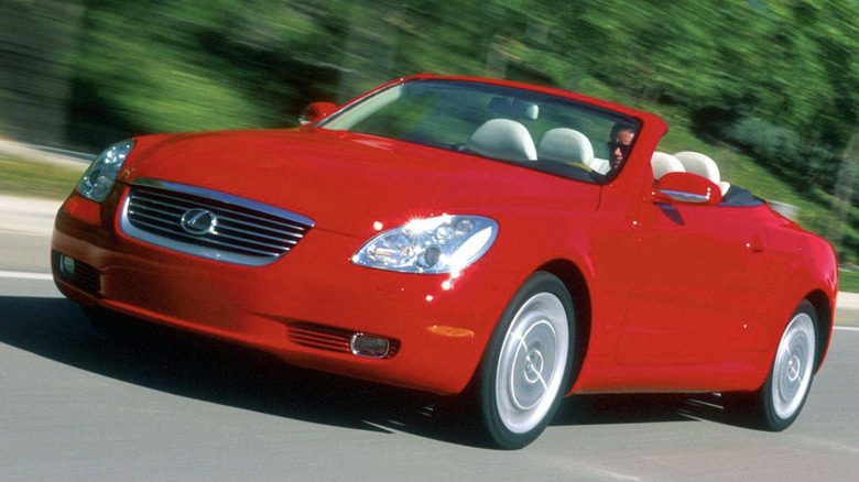 A bright red Lexus SC430 driving down the road