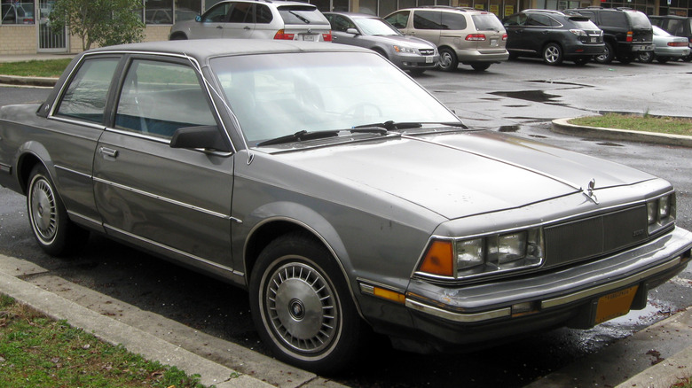 A gray buick century parked in a parking lot
