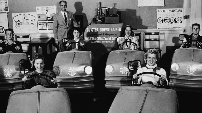 a black and white photo of a high school driving class from the 1940s.