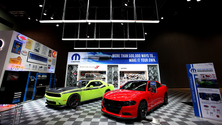 Dodge performance cars parked on checkerboard floor at an auto show