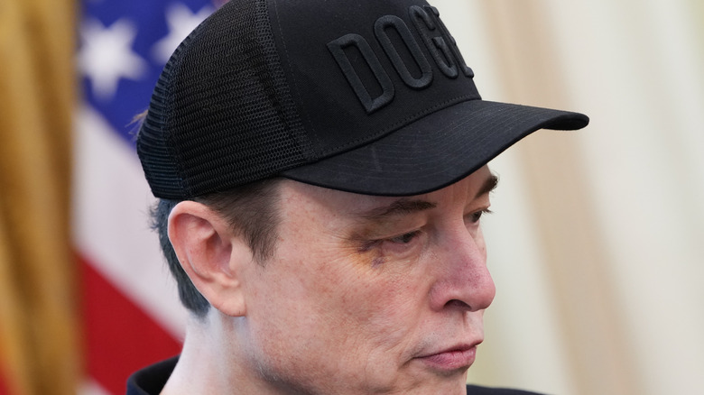 Elon musk looking chopped in a black DOGE hat