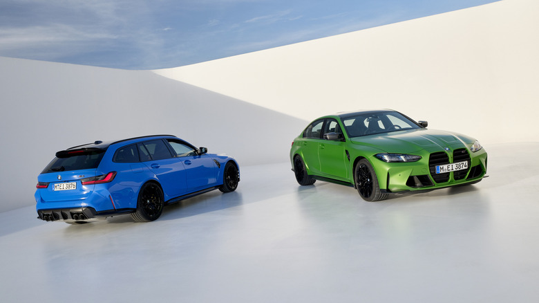 The rear 3/4 of a blue BMW M3 Touring (wagon) and the front of the BMW M3 sedan in a bright green on a white background.