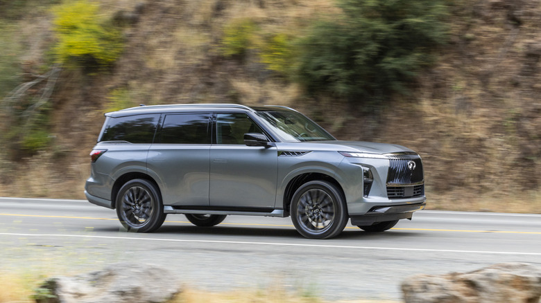 A boring grey-silver 2026 Infiniti QX80 on a mountain-area road.