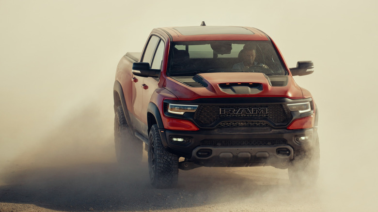 The biggest and most obnoxious of the full-size trucks known to man, the 2024 Ram 1500 TRX surrounded by a cloud of dust as a Ram driver does RAM things.