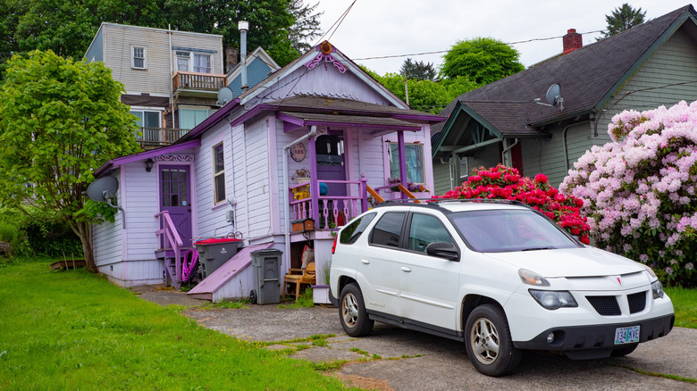 Astoria, Oregon, USA - May 21, 2019: Pontiac Aztek SUV car at suburban house. Residential house in suburban area with Pontiac Aztek. Pontiac Aztek SUV car parked outdoor. Pontiac Aztek, corner view
