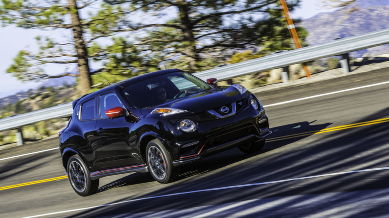 A black Nissan Juke Nismo on a banked mountain road.