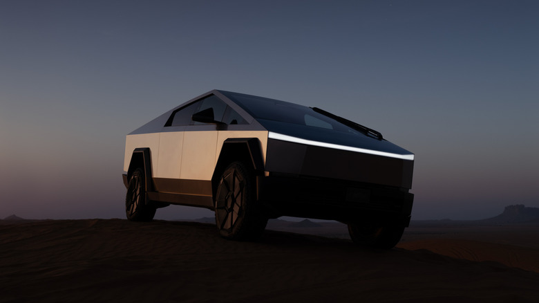 A Tesla Cybertruck parked on a darkened moonlike/desert-like surface.
