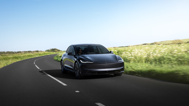 A Tesla Model 3 on a sparse country road.