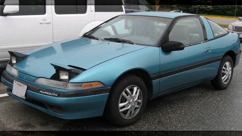A very basic teal base '90s Plymouth Laser in a parking lot.