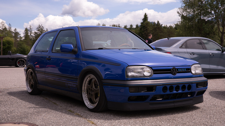 Villach, Austria - Mai 28, 2025: Blue volkswagen gti at car meet with cloudy sky background.