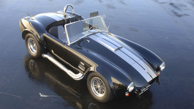overhead shot of a black 427 Shelby Cobra parked on wet asphalt