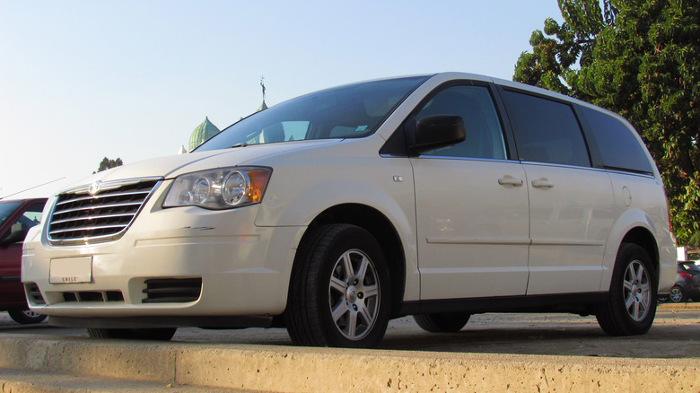 A white Chrysler Town & Country in a parking lot