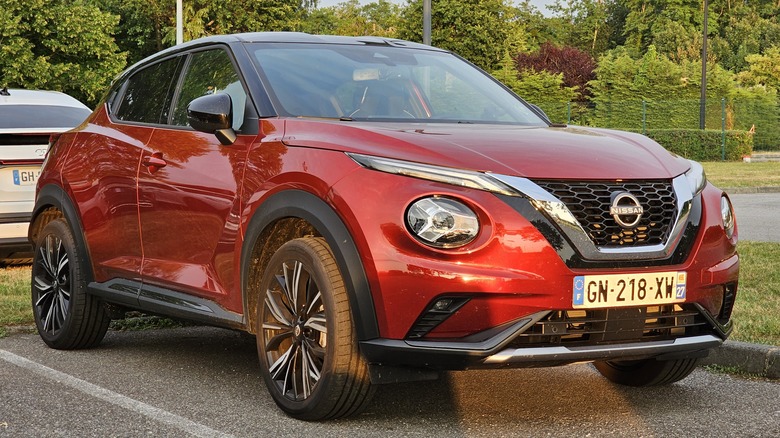 A red Nissan Juke in a parking lot