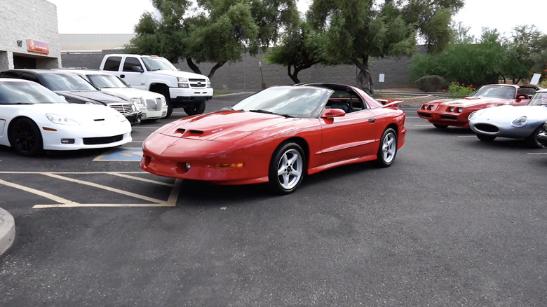 A bright red 1996 Pontiac Trans Am in a parking lot