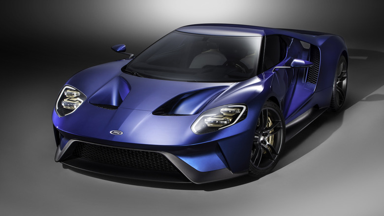 Front three quarters shot of a dark blue Ford GT in front of a greyscale background