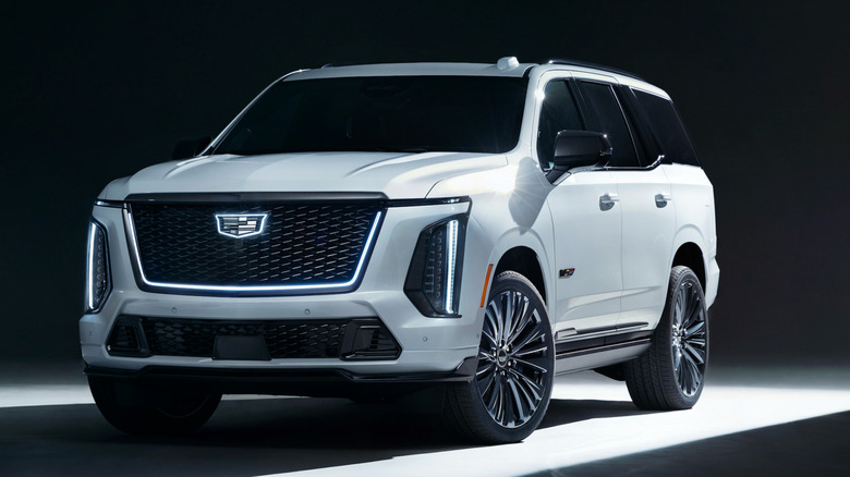 Front three-quarters image of a white Escalade-V Collectors Series parked in a black studio