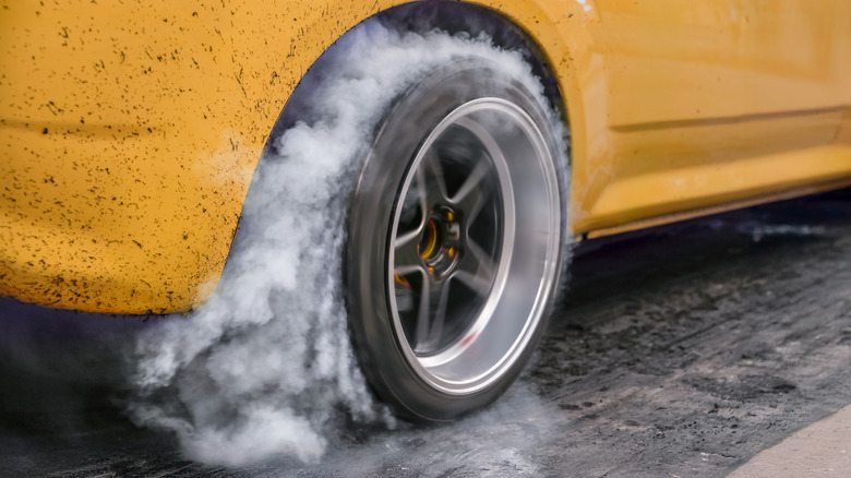 Drag racing car burns rubber off its tires in preparation for the race