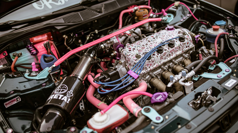Rome, italy 17 june 2025, pink and teal car engine featuring tuning and performance modifications, showcasing a unique and personalized style
