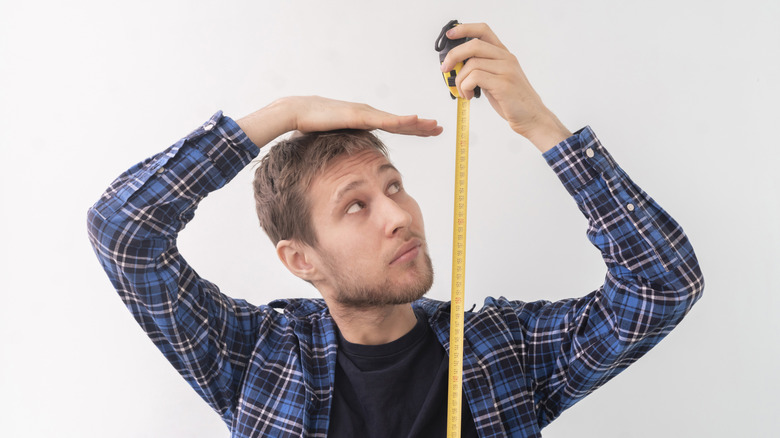 A man measures his height