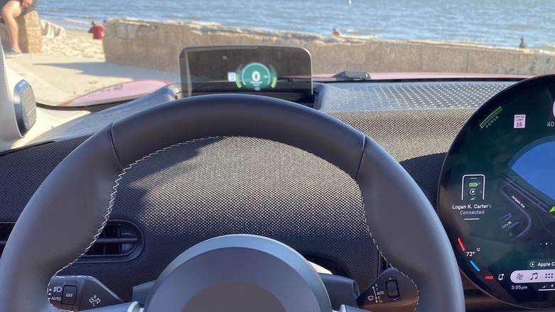 A close-up of the HUD in the new Mini Cooper parked on the beach with the ocean out the windshield