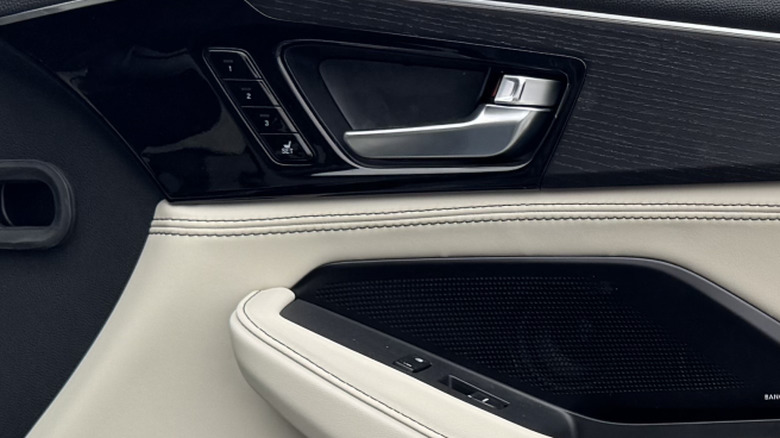 A close-up of the seat memory controls in an Acura MDX with white leather