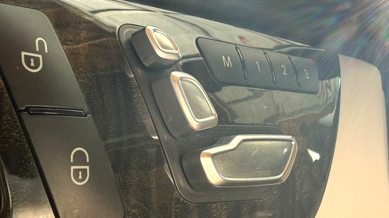 The three button power seat adjustment switches on a Mercedes-Benz door panel.