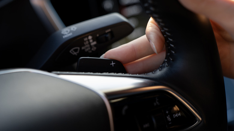 A close-up of a paddle shifter peeking above the steering wheel.
