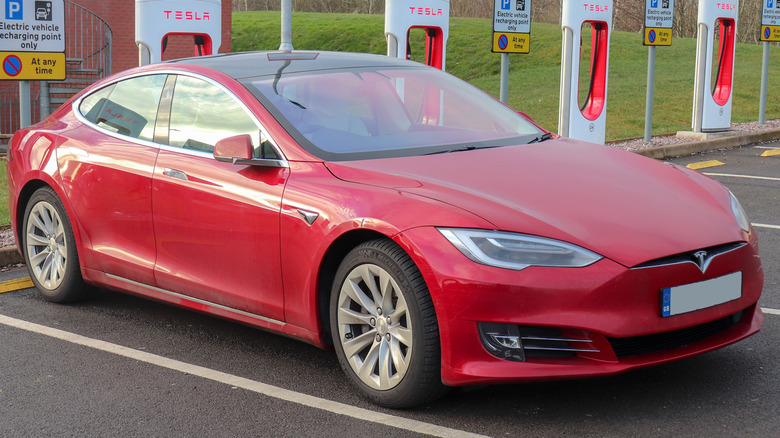 A red 2018 Tesla Model S 75D at a charging station
