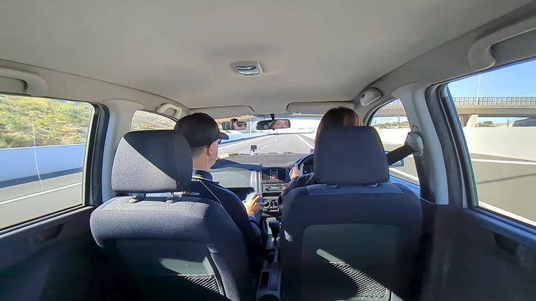 An Australian woman taking driving lessons with instructor in the passenger seat