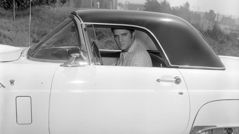 Elvis Presley in the driver's seat in a black and white photo